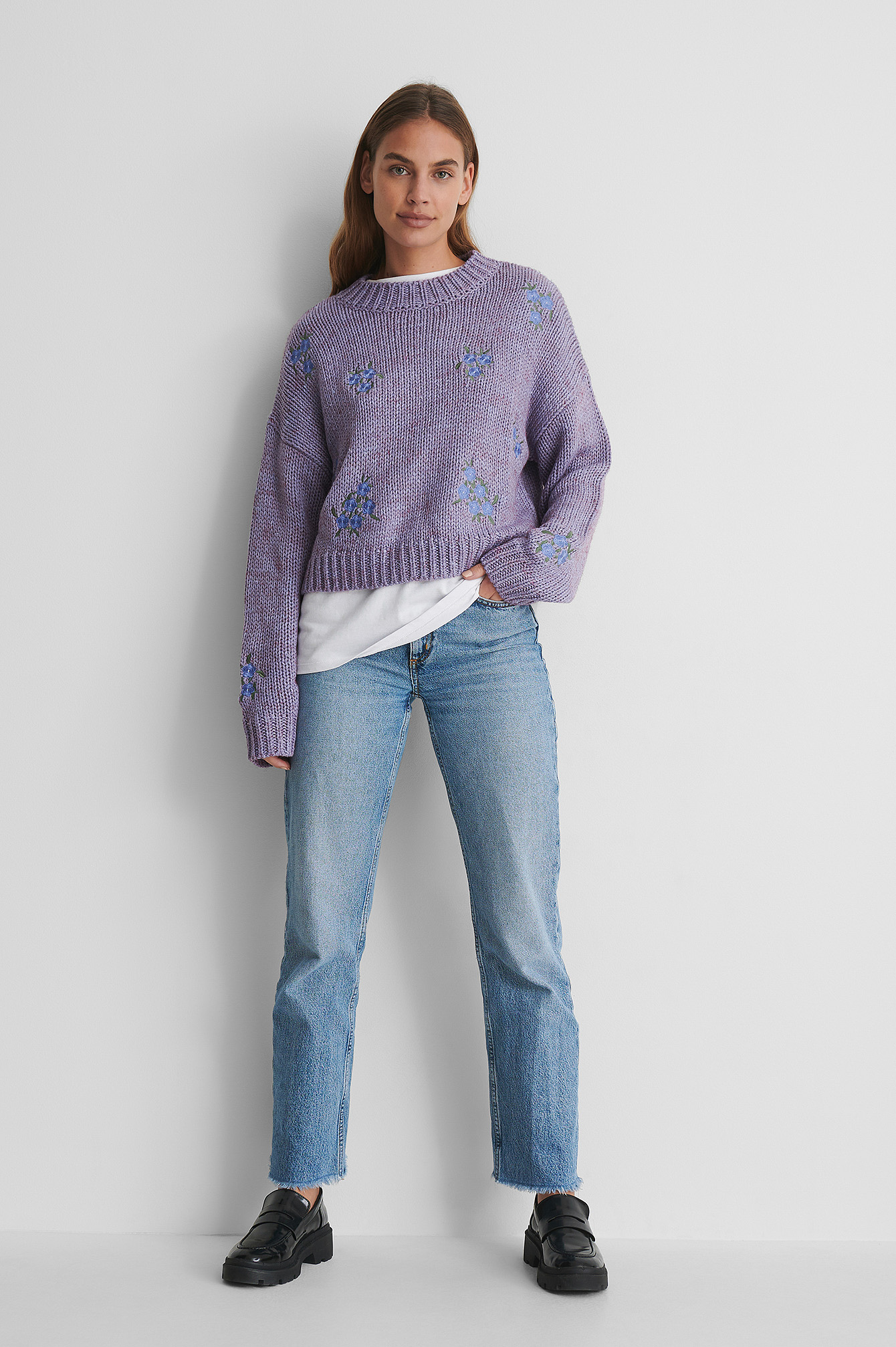 Flower Embroidery Round Neck Knitted Sweater with a White T-shirt and Jeans.